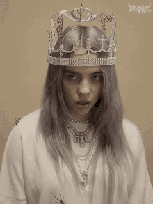 billie eilish wearing a crown and a necklace with the letter b on it