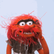 a stuffed animal with red hair and a beard is wearing chains