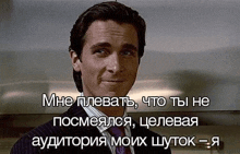 a man in a suit and tie is smiling and looking at the camera with a caption in russian .