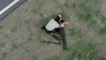 a police officer is kneeling down next to a dead person