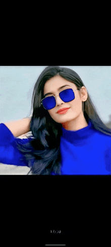 a woman wearing sunglasses and a blue sweater