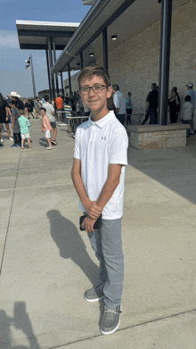 a young boy wearing a white under armour polo shirt