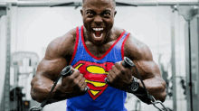 a man in a superman shirt is working out in a gym