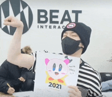 a man wearing a mask holds up a 2021 calendar