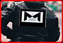 a person wearing a black leather jacket has a large m on the back