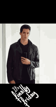 a man in a leather jacket is taking a selfie with a cell phone .