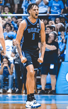 a duke basketball player celebrates a win with his fist in the air