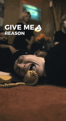 a poster for give me a reason shows a man laying on the floor talking on a phone