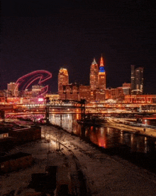 a city skyline at night with a bridge and a river