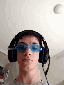 a young boy wearing headphones and goggles looks at the camera