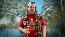 a man in a plaid shirt holds a can of bud light