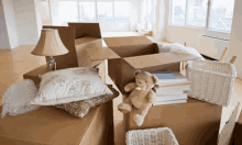 a teddy bear is sitting on top of a cardboard box