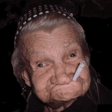 an elderly woman is smoking a cigarette in her mouth and making a funny face .