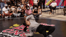 a group of people are sitting on the ground watching a person perform on a stage that has the word bull on it