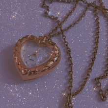 a gold necklace with a heart shaped pendant on a chain