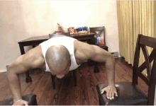 a man is doing push ups on a chair in front of a table with a bag of doritos on it