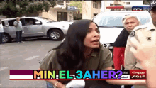 a woman talking to a police officer with the words min el 3aher on the bottom