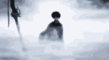 a silhouette of a person standing in the snow with a sword .