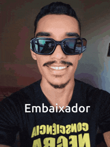 a man wearing sunglasses and a t-shirt that says embaixador