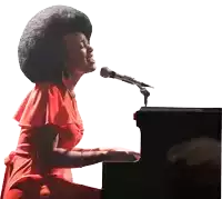 a woman singing into a microphone while playing the piano