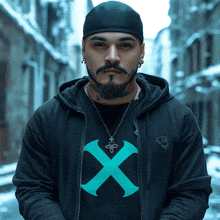 a man with a beard wears a black hoodie with an x on it