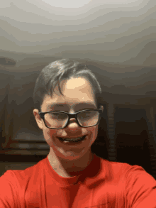 a young boy wearing glasses and a red shirt takes a selfie