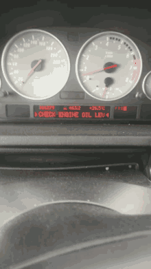 a car dashboard displays a check engine oil lev