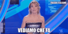 a woman in a strapless dress says vediamo che fa on a blue background