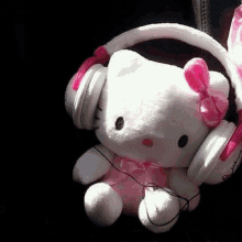 a stuffed hello kitty wearing headphones is sitting in a car .