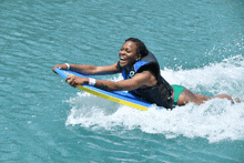 a woman in a life vest is laying on a surfboard in the water