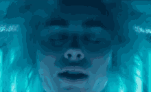 a close up of a person 's face with their eyes closed in a pool of water .