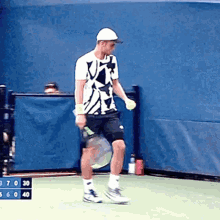 a man is playing tennis on a court with a scoreboard behind him that shows the score of 3 to 30