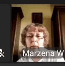 a woman wearing glasses is sitting in front of a computer screen with the name marzena w. on it .