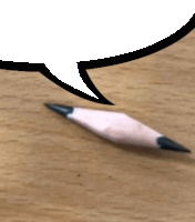 a pencil is laying on a wooden table with a speech bubble above it