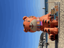 a large inflatable tiger is on the beach with a sign that says 2022