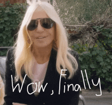 a woman wearing sunglasses says wow finally in white