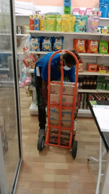 a man wearing a mask is pushing a cart full of boxes including one that says ' a ' on it