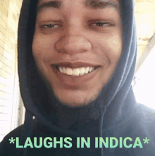 a man wearing a hooded sweatshirt smiles with the words * laughs in indica * below him