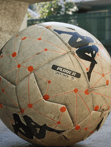 a kappa soccer ball is sitting on a cement surface