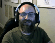 a bald man with a beard wearing headphones and glasses