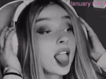 a girl wearing headphones is sticking her tongue out in a black and white photo with january sub 9 in pink