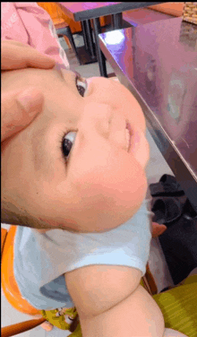 a close up of a baby 's face with a person 's finger on it