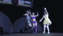 three women are posing for a picture on a stage in front of a sign that says ' ponji '