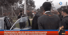 a man wearing a mask is standing in front of a car with the words de produccion nacional on the bottom