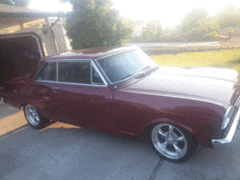 a red car is parked in front of a garage door