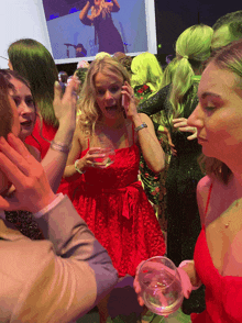 a woman in a red dress holds a glass of water