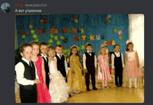 a group of children are standing in front of a blue curtain that says actkuu on it