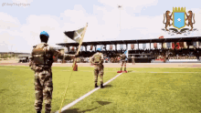 two soldiers are standing on a field with a flag in front of them and the words we the horn on the bottom right