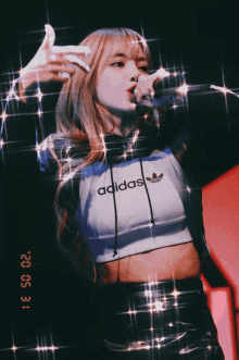 a girl wearing a crop top that says adidas