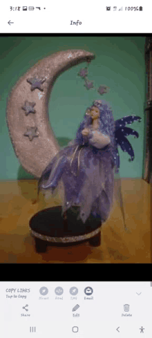 a fairy doll is sitting on a crescent moon